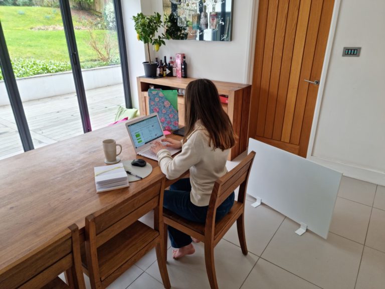 Une femme travaillant à domicile profite de la chaleur du radiateur portable Herschel