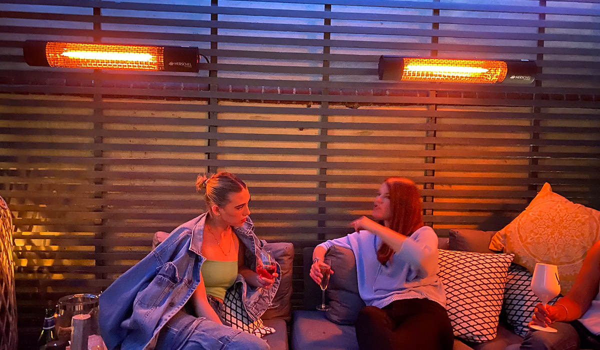 Femmes réchauffées par les radiateurs de terrasse Herchel